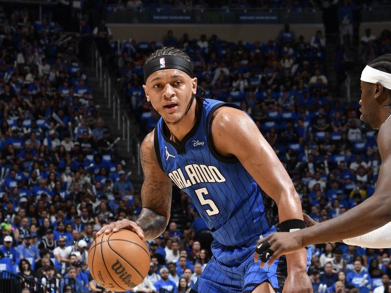 ORLANDO, FL - APRIL 27: Paolo Banchero #5 of the Orlando Magic dribbles the ball during the game against the Cleveland Cavaliers during Round 1 Game 4 of the 2024 NBA Playoffs on April 27, 2024 at the Kia Center in Orlando, Florida. NOTE TO USER: User expressly acknowledges and agrees that, by downloading and or using this photograph, User is consenting to the terms and conditions of the Getty Images License Agreement. Mandatory Copyright Notice: Copyright 2024 NBAE (Photo by Fernando Medina/NBAE via Getty Images)