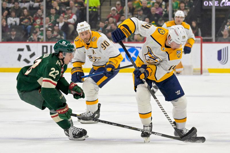 Jan 25, 2024; Saint Paul, Minnesota, USA; Minnesota Wild forward Marco Rossi (23) poke-checks the puck away from Nashville Predators forward Gustav Nyquist (14) during the first period at Xcel Energy Center. Mandatory Credit: Nick Wosika-USA TODAY Sports