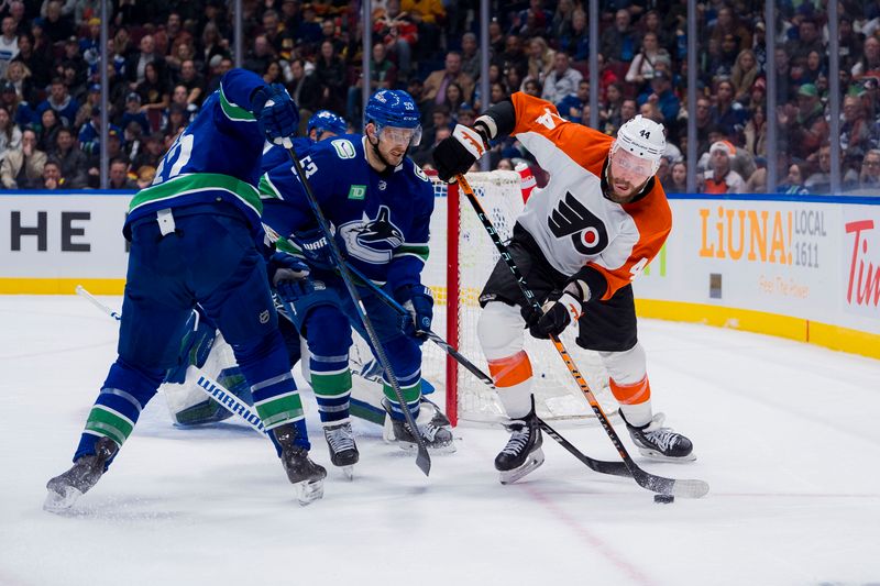 Dec 28, 2023; Vancouver, British Columbia, CAN; Vancouver Canucks defenseman Ian Cole (82) and forward Teddy Blueger (53) battles with Philadelphia Flyers forward Nicolas Deslauriers (44) in the first period at Rogers Arena. Mandatory Credit: Bob Frid-USA TODAY Sports