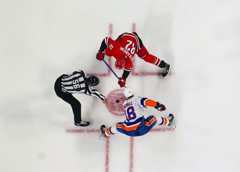 Dec 23, 2023; Raleigh, North Carolina, USA; New York Islanders left wing Pierre Engvall (18) takes face off against Carolina Hurricanes center Jesperi Kotkaniemi (82) during the first period at PNC Arena. Mandatory Credit: James Guillory-USA TODAY Sports