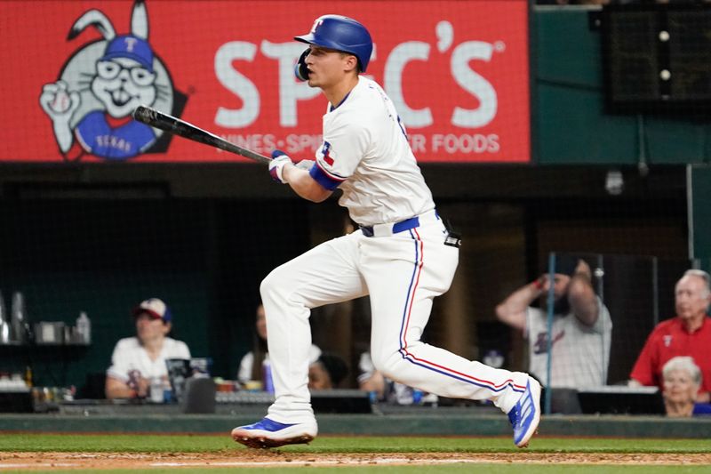 May 18, 2024; Arlington, Texas, USA; Texas Rangers shortstop Corey Seager (5) hits a single during the eighth inning against the Los Angeles Angels at Globe Life Field. Mandatory Credit: Raymond Carlin III-USA TODAY Sports