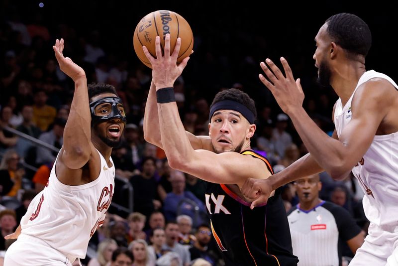 PHOENIX, ARIZONA - APRIL 03: Devin Booker #1 of the Phoenix Suns drives to the basket against Donovan Mitchell #45 and Evan Mobley #4 of the Cleveland Cavaliers during the second half at Footprint Center on April 03, 2024 in Phoenix, Arizona. NOTE TO USER: User expressly acknowledges and agrees that, by downloading and or using this photograph, User is consenting to the terms and conditions of the Getty Images License Agreement.  (Photo by Chris Coduto/Getty Images)