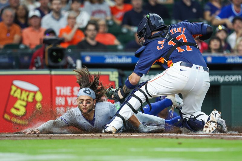 Apr 2, 2024; Houston, Texas, USA; Toronto Blue Jays shortstop Bo Bichette (11) is tagged out by Houston Astros catcher Victor Caratini (17) on a play at the plate during the first inning at Minute Maid Park. Mandatory Credit: Troy Taormina-USA TODAY Sports