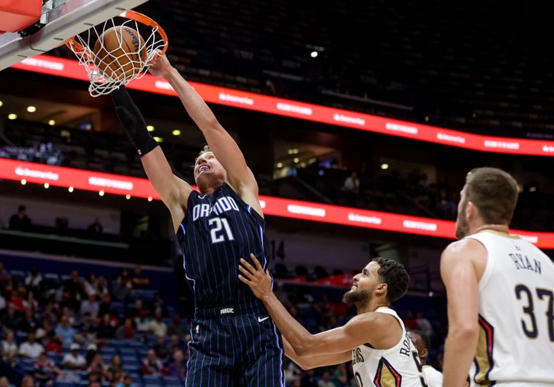 NEW ORLEANS, LOUISIANA - OCTOBER 7:  Moritz Wagner #21 of the Orlando Magic dunks past Jeremiah Robinson-Earl #50 and Matt Ryan #37 of the New Orleans Pelicans during the second half of a preseason game at the Smoothie King Center on October 7, 2024 in New Orleans, Louisiana. NOTE TO USER: User expressly acknowledges and agrees that, by downloading and or using this photograph, User is consenting to the terms and conditions of the Getty Images License Agreement. (Photo by Derick E. Hingle/Getty Images)