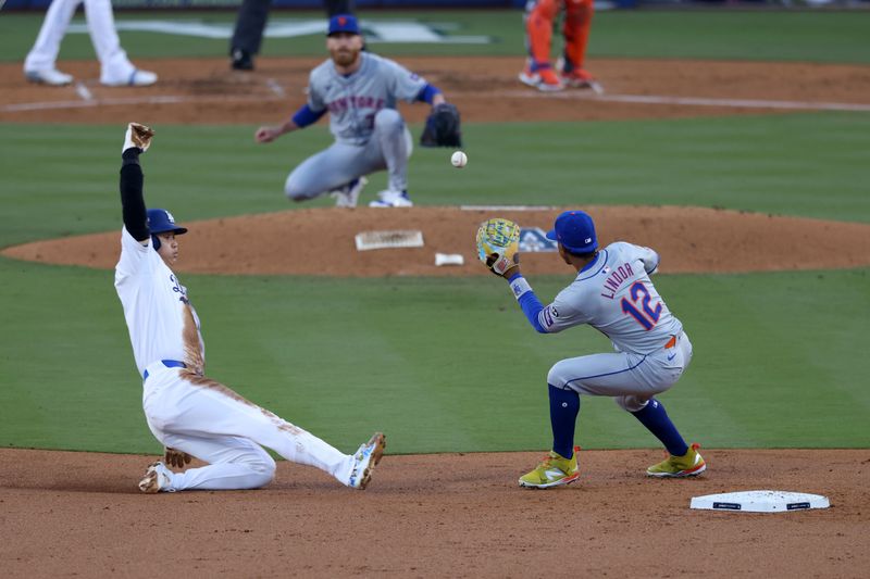 Oct 13, 2024; Los Angeles, California, USA; New York Mets shortstop Francisco Lindor (12) tags out Los Angeles Dodgers two-way player Shohei Ohtani (17) attempting to steal second base in the second inning during game one of the NLCS for the 2024 MLB Playoffs at Dodger Stadium. Mandatory Credit: Jason Parkhurst-Imagn Images