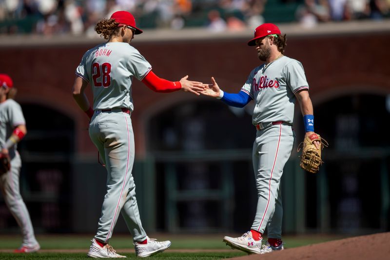 May 29, 2024; San Francisco, California, USA; Philadelphia Phillies third baseman Alec Bohm (28) and first baseman Bryce Harper (3) celebrate their 6-1 victory over the San Francisco Giants at Oracle Park. Mandatory Credit: D. Ross Cameron-USA TODAY Sports