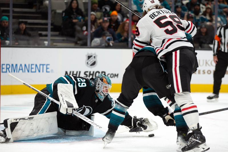 Oct 31, 2024; San Jose, California, USA; San Jose Sharks goaltender Mackenzie Blackwood (29) reaches to glove the puck in front of the net during the first period against the Chicago Blackhawks at SAP Center at San Jose. Mandatory Credit: D. Ross Cameron-Imagn Images