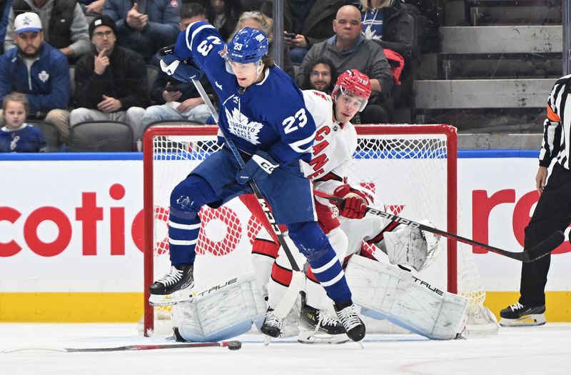 Dec 30, 2023; Toronto, Ontario, CAN; Toronto Maple Leafs forward Matthews Knies (23) tries to redirect the puck into the net past Carolina Hurricanes defenseman Brady Skjei (76) in the second period at Scotiabank Arena. Mandatory Credit: Dan Hamilton-USA TODAY Sports