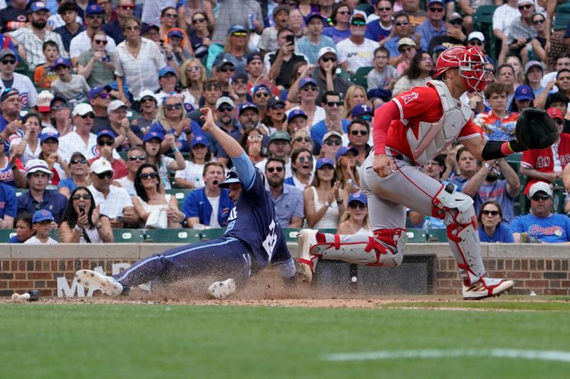 Jul 5, 2024; Chicago, Illinois, USA; Chicago Cubs first baseman Michael Busch (29) is safe at home plate as Los Angeles Angels catcher Logan O'Hoppe (14) takes a late throw during the fifth inning at Wrigley Field. Mandatory Credit: David Banks-USA TODAY Sports