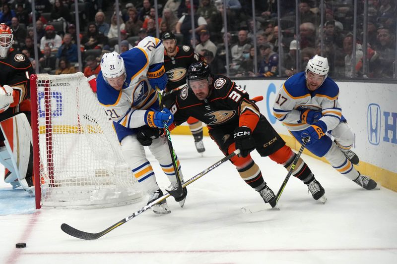 Feb 15, 2023; Anaheim, California, USA; Buffalo Sabres right wing Kyle Okposo (21) and center Tyson Jost (17) battle for the puck with Anaheim Ducks right wing Jakob Silfverberg (33) in the first period at Honda Center. Mandatory Credit: Kirby Lee-USA TODAY Sports