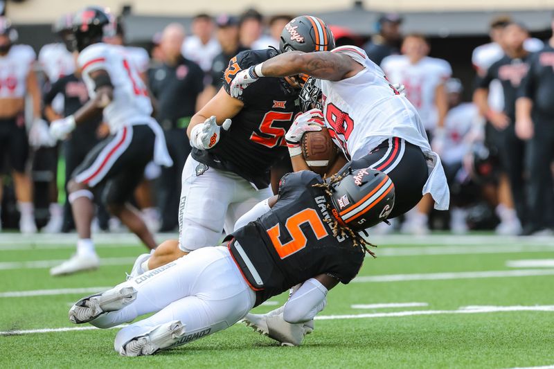 Oct 8, 2022; Stillwater, Oklahoma, USA;  Texas Tech Red Raiders running back Tahj Brooks (28) is taken down by Oklahoma State Cowboys safety Kendal Daniels (5) and defensive end Ben Kopenski (52) in the third quarter at Boone Pickens Stadium. Mandatory Credit: Nathan J Fish/The Oklahoman - USA TODAY NETWORK