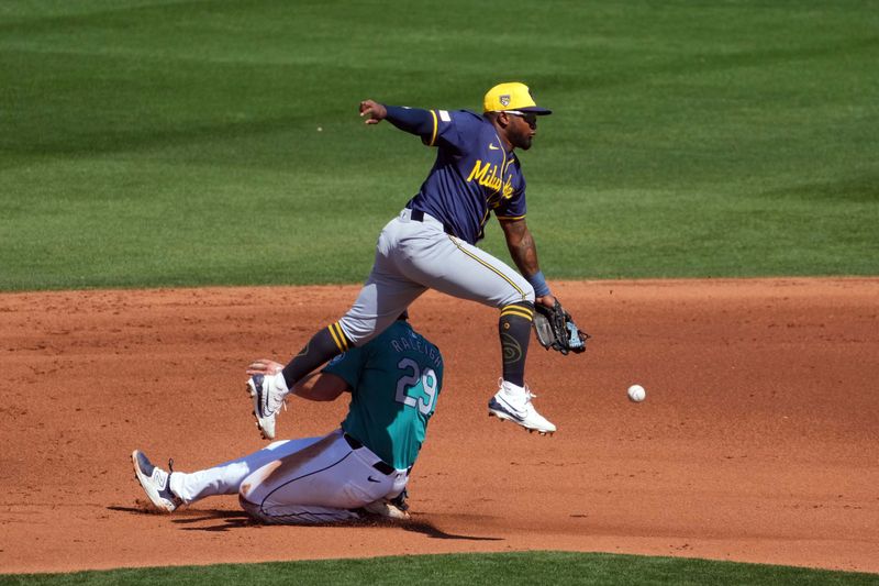 Mar 14, 2024; Peoria, Arizona, USA; Seattle Mariners catcher Cal Raleigh (29) beats a throw to Milwaukee Brewers second baseman Yonny Hernandez (63) to steal second base during the fourth inning at Peoria Sports Complex. Mandatory Credit: Joe Camporeale-USA TODAY Sports