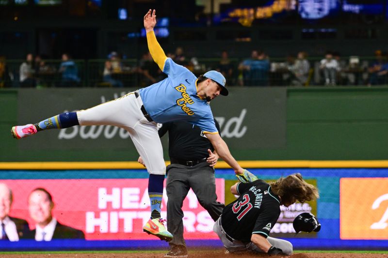 Sep 22, 2024; Milwaukee, Wisconsin, USA; Arizona Diamondbacks center fielder Jake McCarthy (31) steals second base as Milwaukee Brewers shortstop Willy Adames (27) attempts to make a tag in the third inning at American Family Field. Mandatory Credit: Benny Sieu-Imagn Images