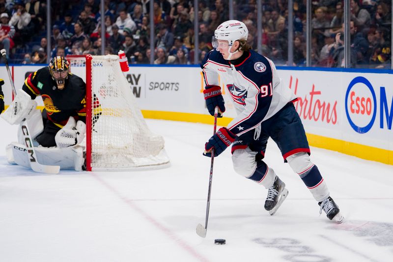 Jan 27, 2024; Vancouver, British Columbia, CAN; Columbus Blue Jackets forward Kent Johnson (91) handles the puck against the Vancouver Canucks in the first period at Rogers Arena. Mandatory Credit: Bob Frid-USA TODAY Sports