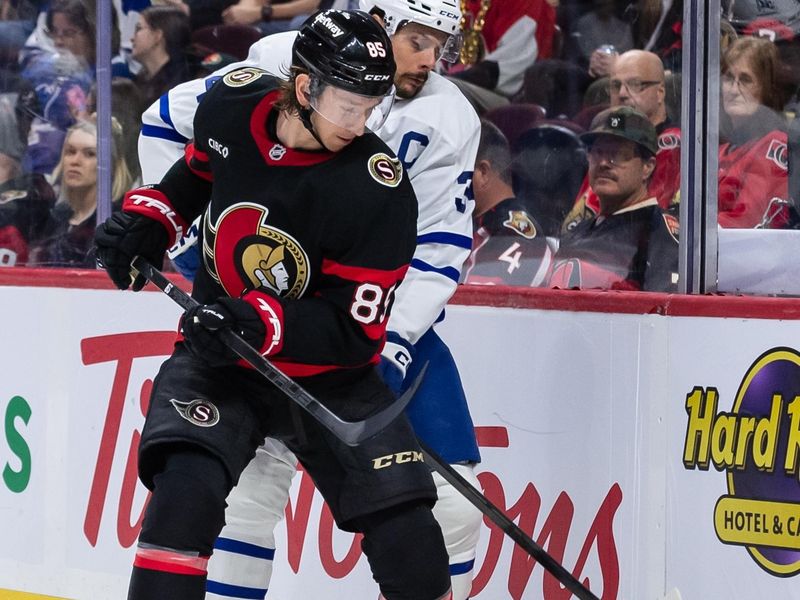 Jan 25, 2025; Ottawa, Ontario, CAN; Toronto Maple Leafs center Auston Matthews (34) battles with Ottawa Senators defenseman Jake Sanderson (85) in the second period at the Canadian Tire Centre. Mandatory Credit: Marc DesRosiers-Imagn Images