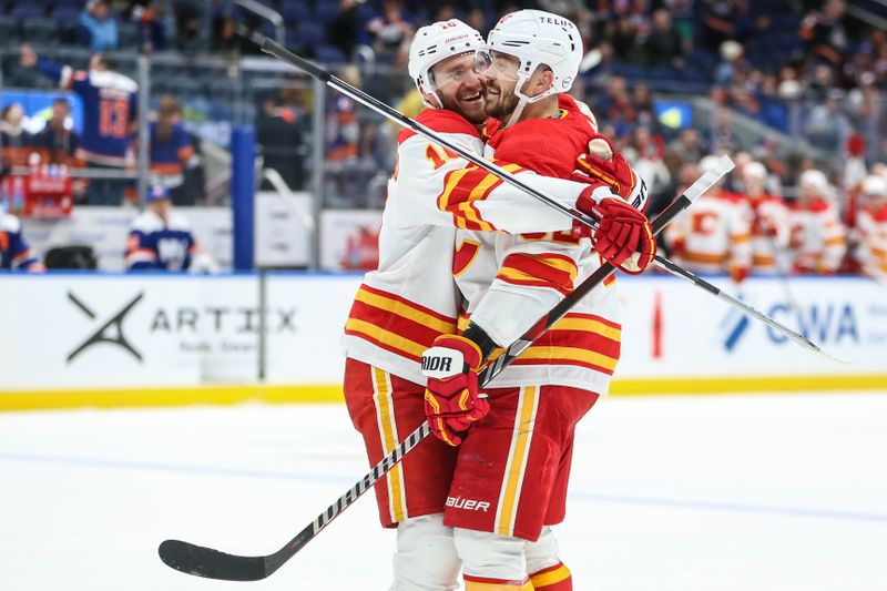 Feb 10, 2024; Elmont, New York, USA;  Calgary Flames defenseman MacKenzie Weegar (52) is greeted by center Jonathan Huberdeau (10) after scoring his third goal of the game in the third period New York Islanders at UBS Arena. Mandatory Credit: Wendell Cruz-USA TODAY Sports