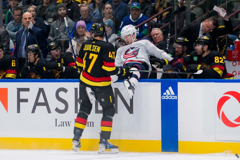 Jan 27, 2024; Vancouver, British Columbia, CAN; Vancouver Canucks defenseman Noah Juulsen (47) checks Columbus Blue Jackets forward Adam Fantilli (11) into the Canucks bench in the third period at Rogers Arena. Canucks won 5-4 in overtime. Mandatory Credit: Bob Frid-USA TODAY Sports