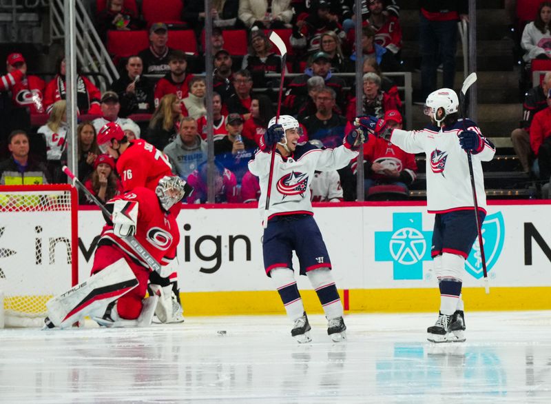 Nov 26, 2023; Raleigh, North Carolina, USA; Columbus Blue Jackets right wing Yegor Chinakhov (59) celebrates his goal with left wing Johnny Gaudreau (13) against the Carolina Hurricanes during the third period at PNC Arena. Mandatory Credit: James Guillory-USA TODAY Sports