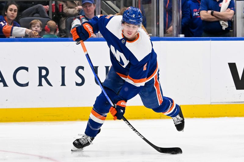 Mar 24, 2024; Elmont, New York, USA;  New York Islanders defenseman Mike Reilly (2) attempts a shot against the New Jersey Devilsa during the second period at UBS Arena. Mandatory Credit: Dennis Schneidler-USA TODAY Sports