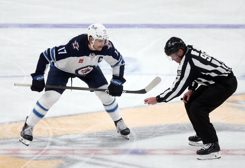 Nov 22, 2024; Pittsburgh, Pennsylvania, USA; Winnipeg Jets center Adam Lowry (17) talks with linesman David Brisebois (96) before a face-off against the Pittsburgh Penguins during the second period at PPG Paints Arena. Mandatory Credit: Charles LeClaire-Imagn Images