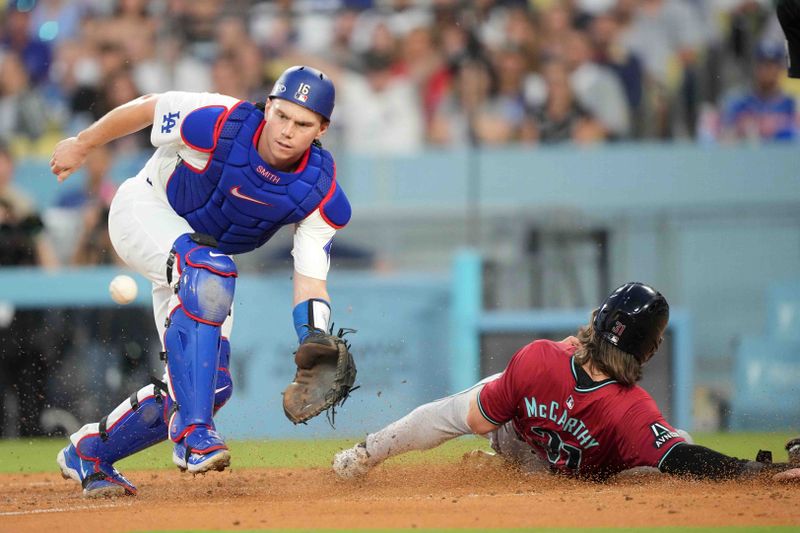 Jul 3, 2024; Los Angeles, California, USA; Arizona Diamondbacks right fielder Jake McCarthy (31) slides into home plate to beat a throw to Los Angeles Dodgers catcher Will Smith (16) to score in the third inning at Dodger Stadium. Mandatory Credit: Kirby Lee-USA TODAY Sports