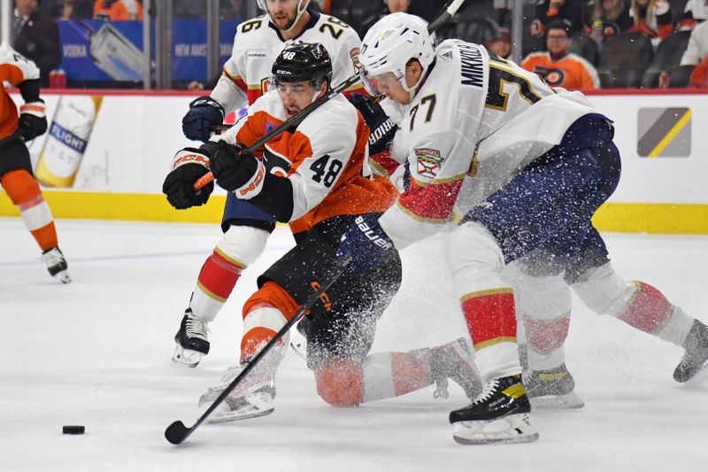 Mar 24, 2024; Philadelphia, Pennsylvania, USA; Philadelphia Flyers center Morgan Frost (48) and Florida Panthers defenseman Niko Mikkola (77) battle for the puck during the third period at Wells Fargo Center. Mandatory Credit: Eric Hartline-USA TODAY Sports