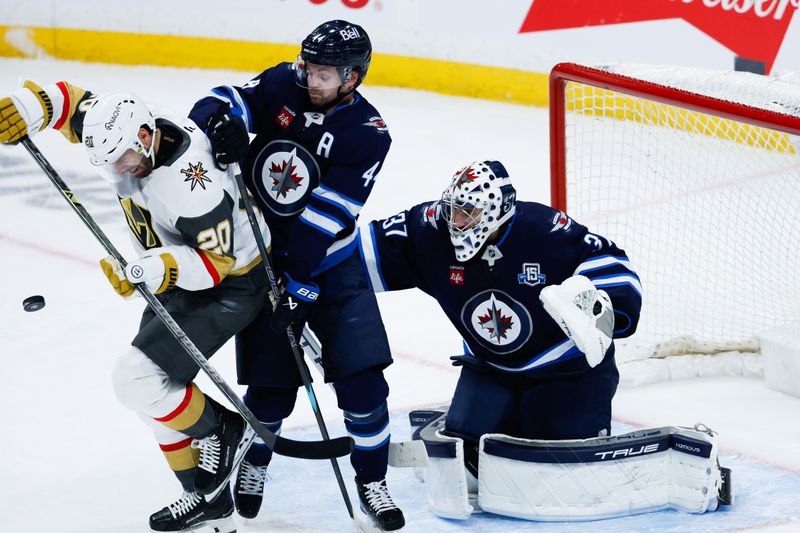 Jan 6, 2026; Winnipeg, Manitoba, CAN;  Vegas Golden Knights forward Brandon Saad( 20) jostles for position with Winnipeg Jets defenseman Josh Morrissey (44) in front of Winnipeg Jets goalie Connor Hellebuyck (37) during the third period at Canada Life Centre. Mandatory Credit: Terrence Lee-Imagn Images