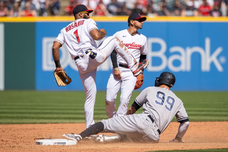 Apr 12, 2023; Cleveland, Ohio, USA; Cleveland Guardians shortstop Amed Rosario (1) avoids New York Yankees designated hitter Aaron Judge (99) and turns the double play during the sixth inning at Progressive Field. Mandatory Credit: Ken Blaze-USA TODAY Sports