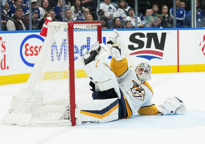 Dec 9, 2023; Toronto, Ontario, CAN; Nashville Predators goaltender Kevin Lankinen (32) tries to stop a puck against the Toronto Maple Leafs during the first period at Scotiabank Arena. Mandatory Credit: Nick Turchiaro-USA TODAY Sports