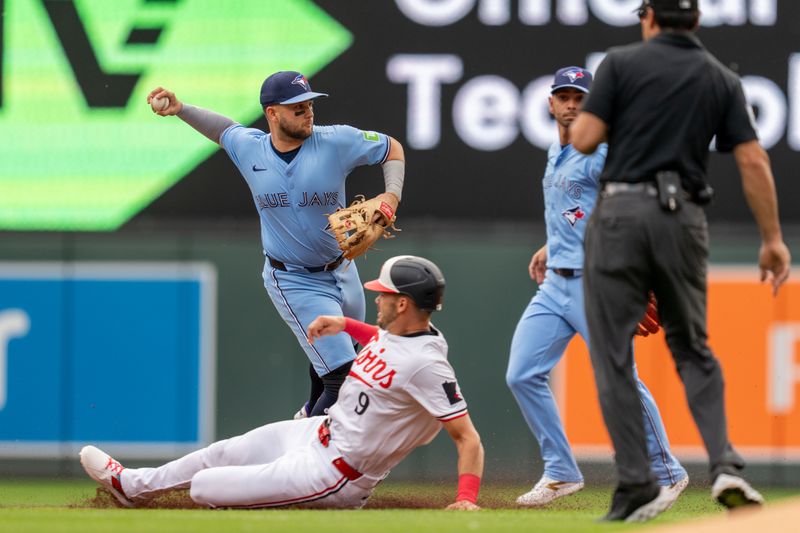 Jun 7, 2025; Minneapolis, Minnesota, USA; Toronto Blue Jays shortstop Bo Bichette (11) turns the double play off a ball hit by Minnesota Twins shortstop Carlos Correa (4) retiring outfielder Trevor Larnach (9) in the first inning at Target Field. Mandatory Credit: Matt Blewett-Imagn Images