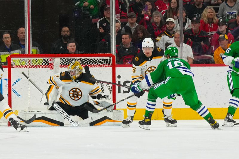 Mar 26, 2023; Raleigh, North Carolina, USA;  Carolina Hurricanes center Jack Drury (18) scores a goal past Boston Bruins goaltender Jeremy Swayman (1) during the second period at PNC Arena. Mandatory Credit: James Guillory-USA TODAY Sports