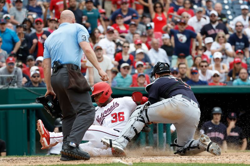 Apr 16, 2023; Washington, District of Columbia, USA; Washington Nationals left fielder Stone Garrett (36) collides with Cleveland Guardians catcher Mike Zunino (10) at home plate while attempting to score a run on a sacrifice fly hit by Nationals right fielder Lane Thomas (not pictured) during the eighth inning at Nationals Park. Garrett was ruled safe after the call on the field was overturned after a challenge review by the Nationals. Mandatory Credit: Geoff Burke-USA TODAY Sports