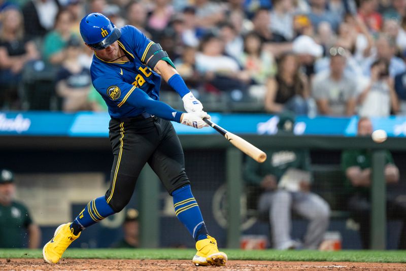 May 10, 2024; Seattle, Washington, USA; Seattle Mariners shortstop Dylan Moore (25) hits a two-run single during the fifth inning against the Oakland Athletics at T-Mobile Park. Mandatory Credit: Stephen Brashear-USA TODAY Sports