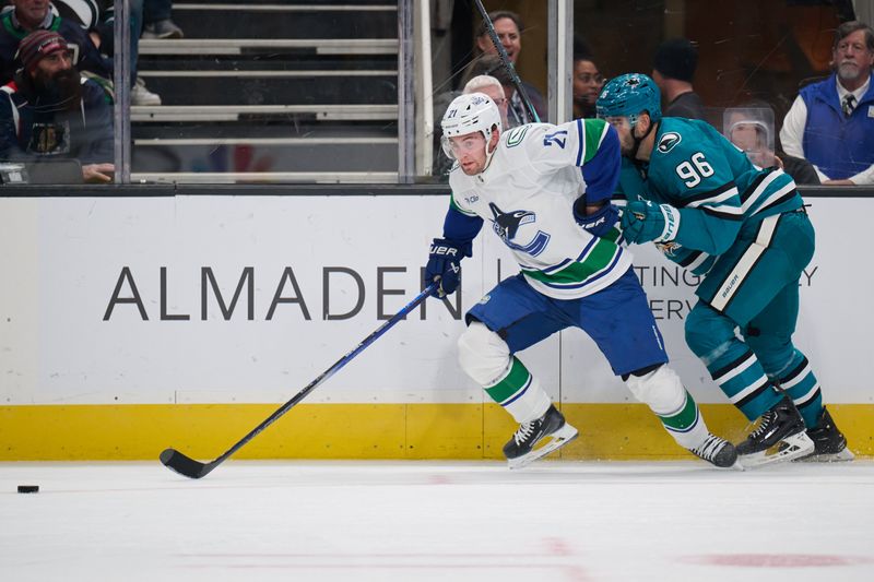 Nov 2, 2024; San Jose, California, USA; Vancouver Canucks left wing Nils Hoglander (21) controls the puck against San Jose Sharks defenseman Jake Walman (96) during the first period at SAP Center at San Jose. Mandatory Credit: Robert Edwards-Imagn Images