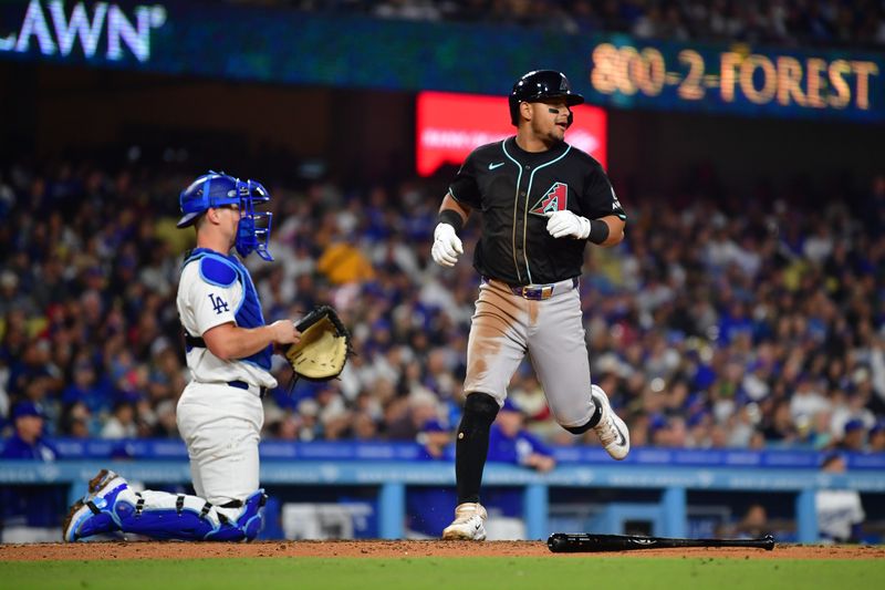 May 22, 2024; Los Angeles, California, USA; Arizona Diamondbacks catcher Gabriel Moreno (14) scores a run against the Los Angeles Dodgers during the fifth inning at Dodger Stadium. Mandatory Credit: Gary A. Vasquez-USA TODAY Sports