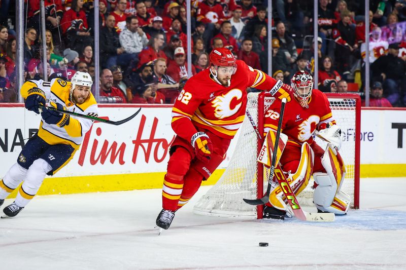 Nov 15, 2024; Calgary, Alberta, CAN; Calgary Flames defenseman Daniil Miromanov (62) controls the puck against the Nashville Predators in front of Calgary Flames goaltender Dustin Wolf (32) during the third period at Scotiabank Saddledome. Mandatory Credit: Sergei Belski-Imagn Images