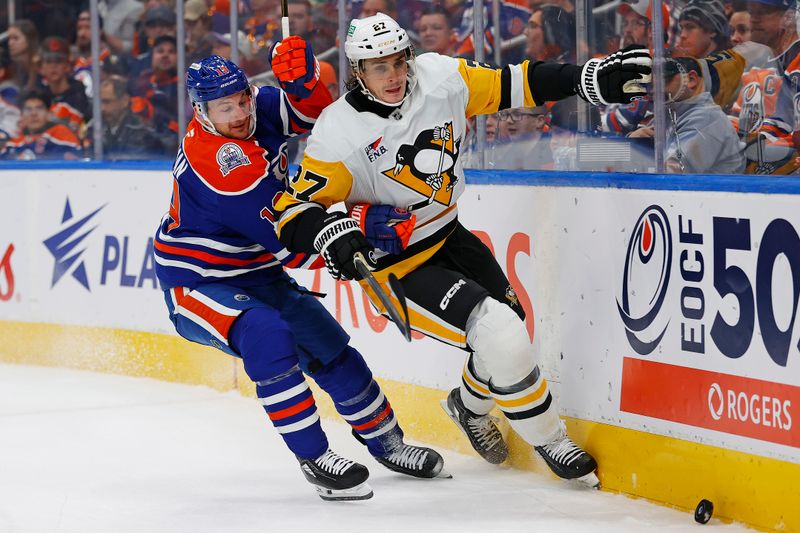 Oct 25, 2024; Edmonton, Alberta, CAN; Pittsburgh Penguins defensemen Ryan Graves (27) and Edmonton Oilers forward Zach Hyman (18) battle along the boards for a loose puck during the first period at Rogers Place. Mandatory Credit: Perry Nelson-Imagn Images