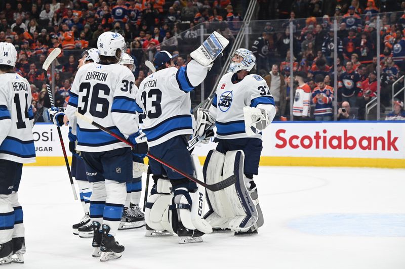 Dec 31, 2022; Edmonton, Alberta, CAN; Winnipeg Jets goalie David Rittich (33) celebrates with Jets goalie Connor Hellebuyck (37) after defeating the Edmonton Oilers at Rogers Place. Winnipeg won 2-1. Mandatory Credit: Walter Tychnowicz-USA TODAY Sports