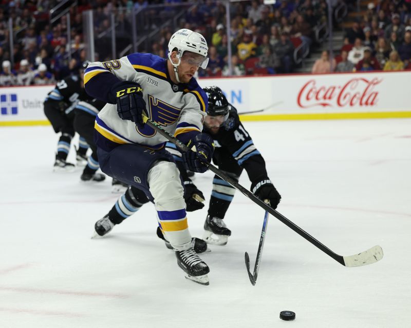 Sep 22, 2024; Des Moines, Iowa, USA; St. Louis Blues center Zach Dean (52) battles Utah Hockey Club defenseman Robert Bortuzzo (41) for the puck during their game at Wells Fargo Arena. Mandatory Credit: Reese Strickland-Imagn Images

