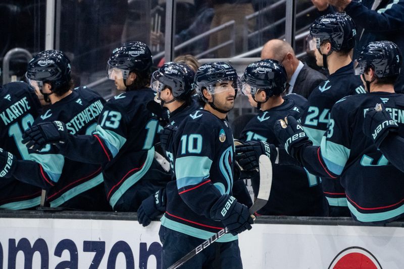 Nov 14, 2024; Seattle, Washington, USA;  Seattle Kraken forward Matty Beniers (10) is congratulated by teammates on the bench after scoring a goal during the second period against the Chicago Blackhawks at Climate Pledge Arena. Mandatory Credit: Stephen Brashear-Imagn Images