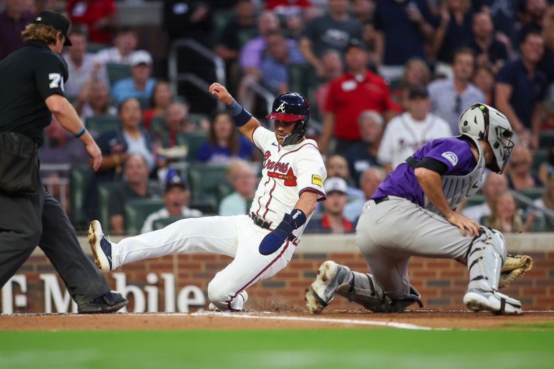 Sep 3, 2024; Atlanta, Georgia, USA; Atlanta Braves second baseman Whit Merrifield (15) slides safely past Colorado Rockies catcher Jacob Stallings (25) to score a run in the third inning at Truist Park. Mandatory Credit: Brett Davis-Imagn Images 
