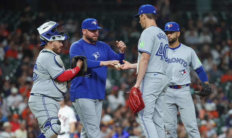 Apr 3, 2024; Houston, Texas, USA; Toronto Blue Jays starting pitcher Chris Bassitt (40) hands the ball to manager John Schneider during a pitching change in the fifth inning against the Houston Astros at Minute Maid Park. Mandatory Credit: Troy Taormina-USA TODAY Sports