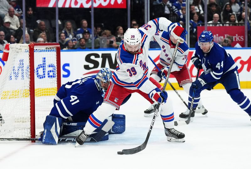 Oct 19, 2024; Toronto, Ontario, CAN; New York Rangers center Sam Carrick (39) battles for the puck in front of Toronto Maple Leafs goaltender Anthony Stolarz (41) during the second period at Scotiabank Arena. Mandatory Credit: Nick Turchiaro-Imagn Images