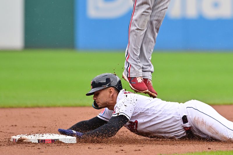 Sep 6, 2023; Cleveland, Ohio, USA; Cleveland Guardians second baseman Andres Gimenez (0) steals second under the legs of Minnesota Twins second baseman Jorge Polanco (11) during the fourth inning at Progressive Field. Mandatory Credit: Ken Blaze-USA TODAY Sports