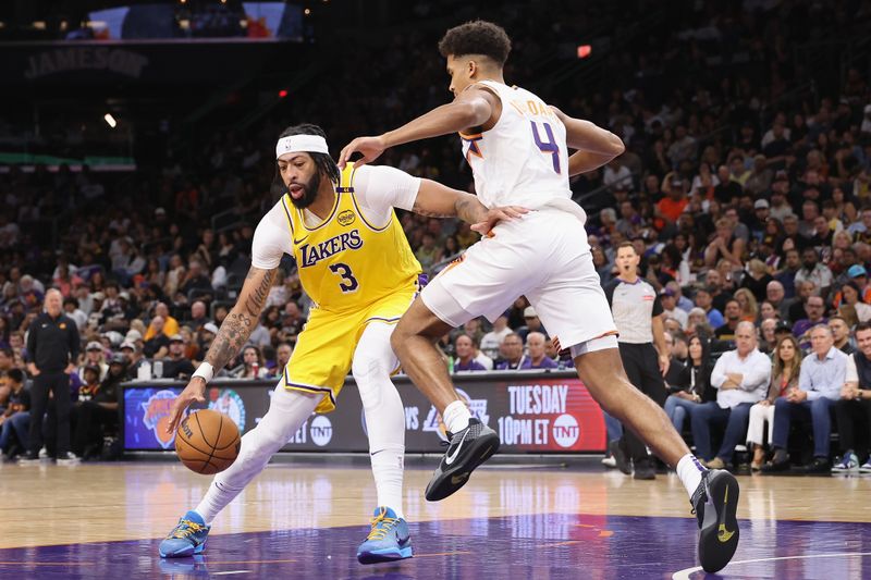 PHOENIX, ARIZONA - OCTOBER 17: Anthony Davis #3 of the Los Angeles Lakers handles the ball against Oso Ighodaro #4 of the Phoenix Suns during the first half of the preseason NBA game at Footprint Center on October 17, 2024 in Phoenix, Arizona. NOTE TO USER: User expressly acknowledges and agrees that, by downloading and/or using this photograph, user is consenting to the terms and conditions of the Getty Images License Agreement.  (Photo by Christian Petersen/Getty Images)