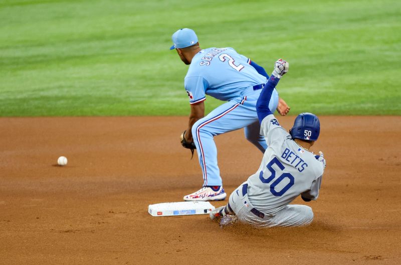 Jul 23, 2023; Arlington, Texas, USA;  Los Angeles Dodgers second baseman Mookie Betts (50) slides safely into second base ahead of the tag by Texas Rangers second baseman Marcus Semien (2) during the first inning at Globe Life Field. Mandatory Credit: Kevin Jairaj-USA TODAY Sports