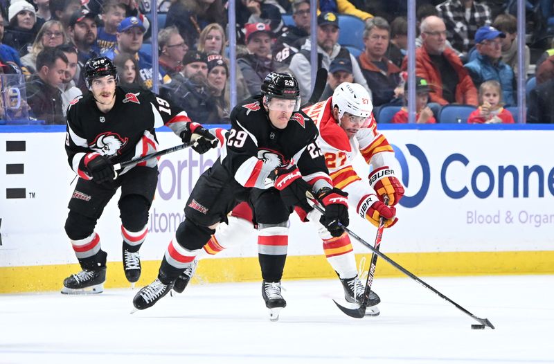 Nov 19, 2025; Buffalo, New York, USA; Buffalo Sabres left wing Beck Malenstyn (29) and Calgary Flames right wing Matt Coronato (27) battle for the puck in the second period at KeyBank Center. Mandatory Credit: Mark Konezny-Imagn Images