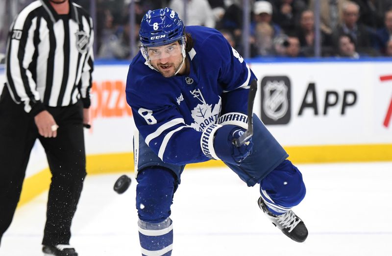 Oct 31, 2024; Toronto, Ontario, CAN;  Toronto Maple Leafs defenseman Chris Tanev (8) shoots the puck into the Seattle Kraken zone in the first period at Scotiabank Arena. Mandatory Credit: Dan Hamilton-Imagn Images