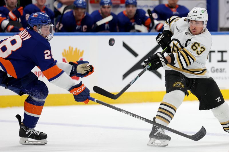 Mar 2, 2024; Elmont, New York, USA; Boston Bruins left wing Brad Marchand (63) takes a shot against New York Islanders defenseman Alexander Romanov (28) during the first period at UBS Arena. Mandatory Credit: Brad Penner-USA TODAY Sports