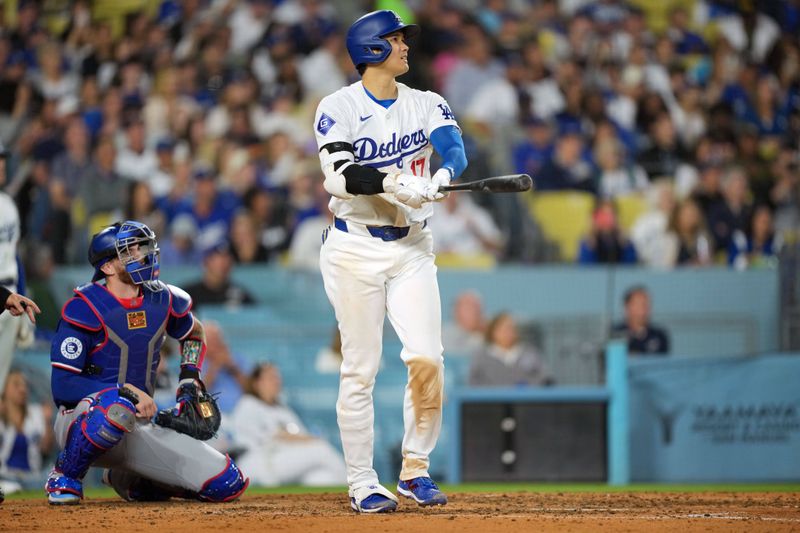 Jun 11, 2024; Los Angeles, California, USA; Los Angeles Dodgers designated hitter Shohei Ohtani (17) hits a two-run home run in the sixth inning as Texas Rangers catcher Jonah Heim (28) watches at Dodger Stadium. Mandatory Credit: Kirby Lee-USA TODAY Sports